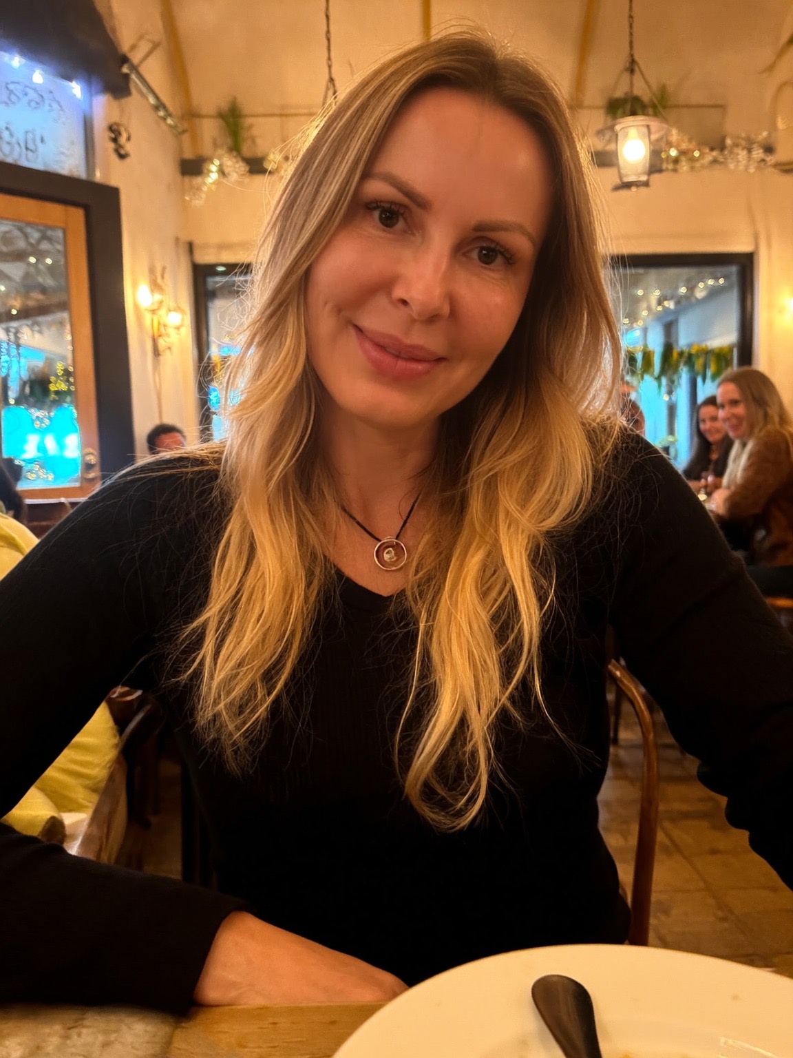 Sylwia Sitkowska w czarnym swetrze, siedząca przy stole podczas rozmowy